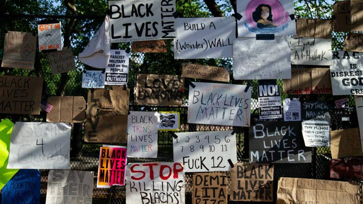 Black Lives Matter protest signs on White House fence.