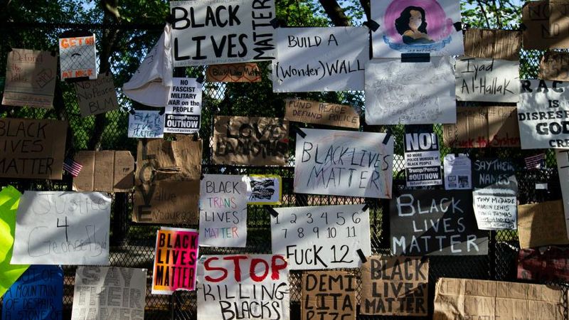 Black Lives Matter protest signs on White House fence.