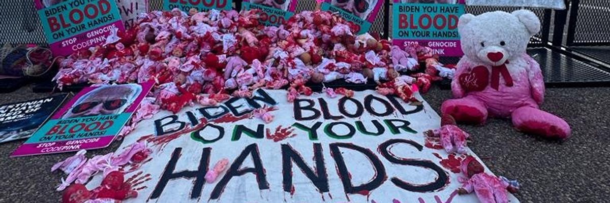 Bloodied baby dolls and sign that reads "Biden, Blood on Your Hands"