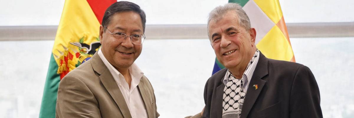 Bolivian President Luis Arce shakes hands with Palestine's ambassador.
