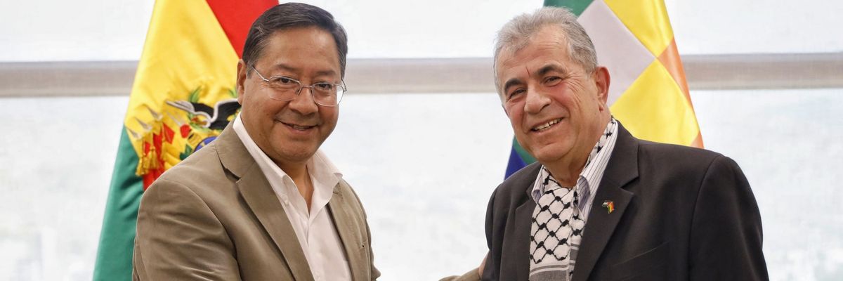 Bolivian President Luis Arce shakes hands with Palestine's ambassador.