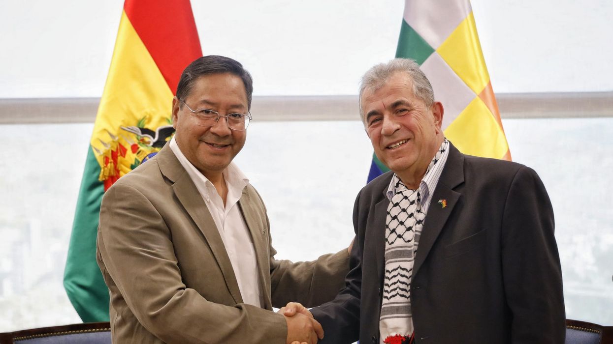 Bolivian President Luis Arce shakes hands with Palestine's ambassador.