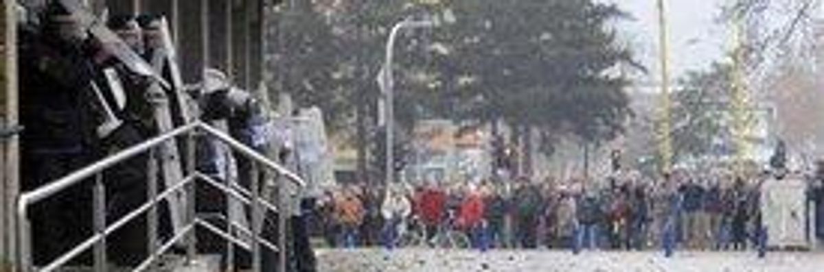Bosnian police forces secure the entrance as protesters stoned a local government building in the Bosnian town of Tuzla, 140 kms north of Sarajevo, Thursday, Feb. 6, 2014.