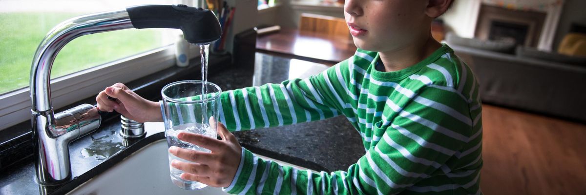 Boy pouring drinking water into a glass
