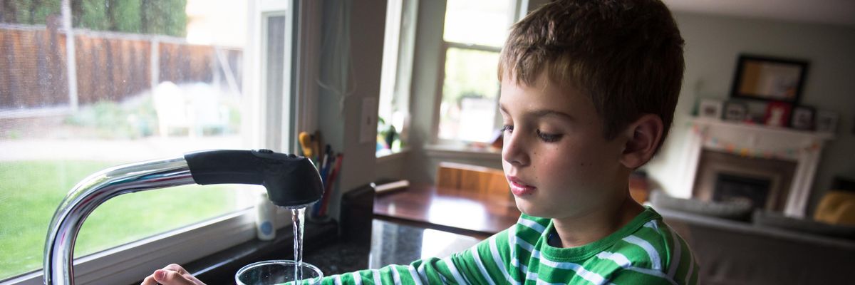 Boy pouring drinking water into a glass