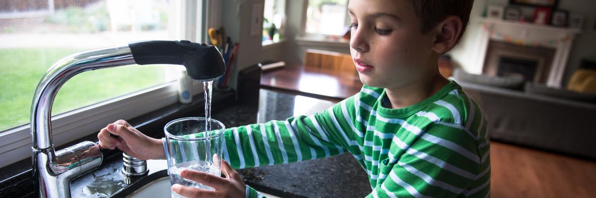 Boy pouring drinking water into a glass