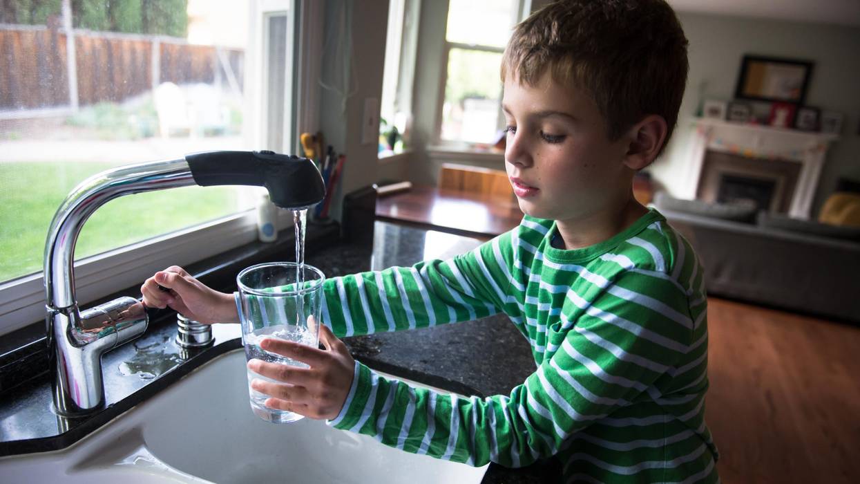 Boy pouring drinking water into a glass