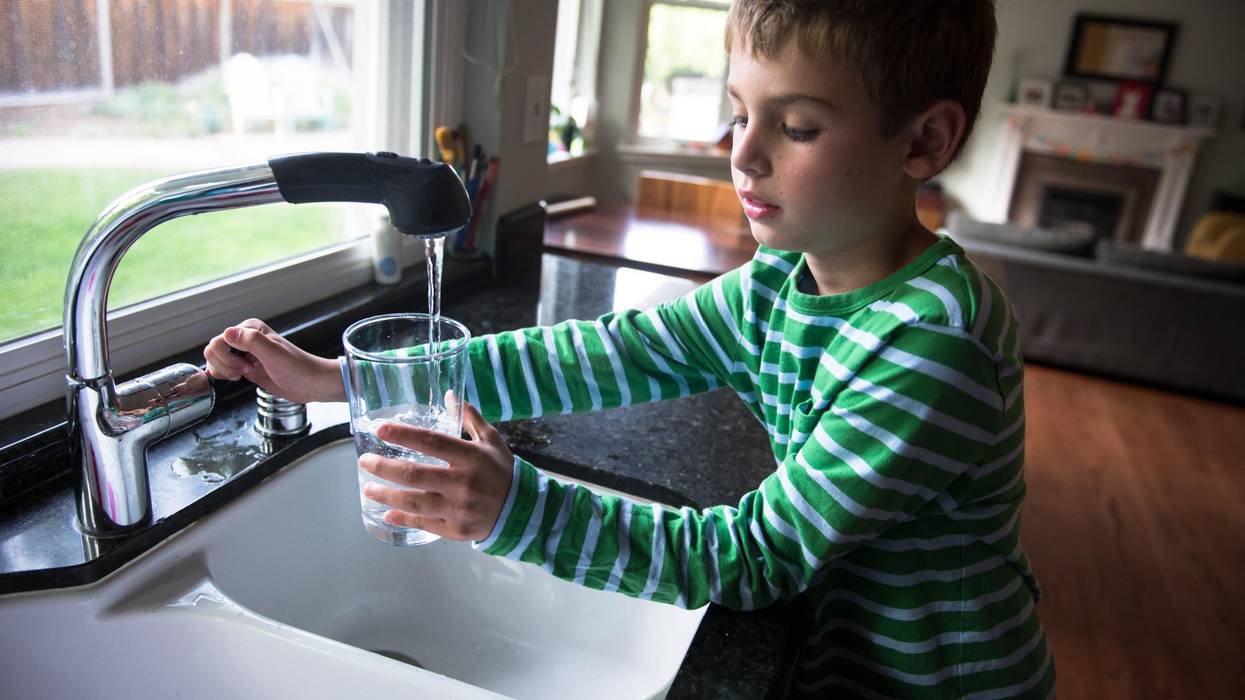 Boy pouring drinking water into a glass