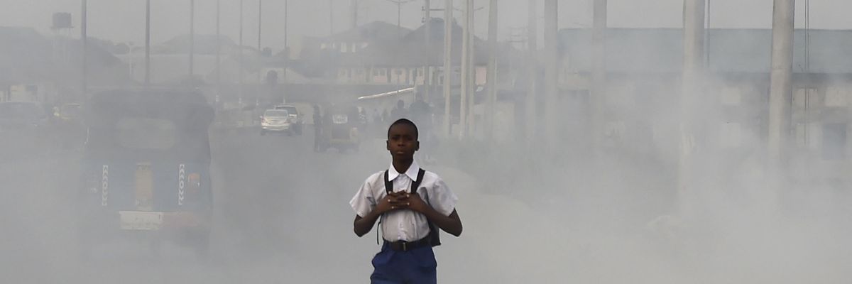 Boy walks through smog in Port Harcourt, Nigeria