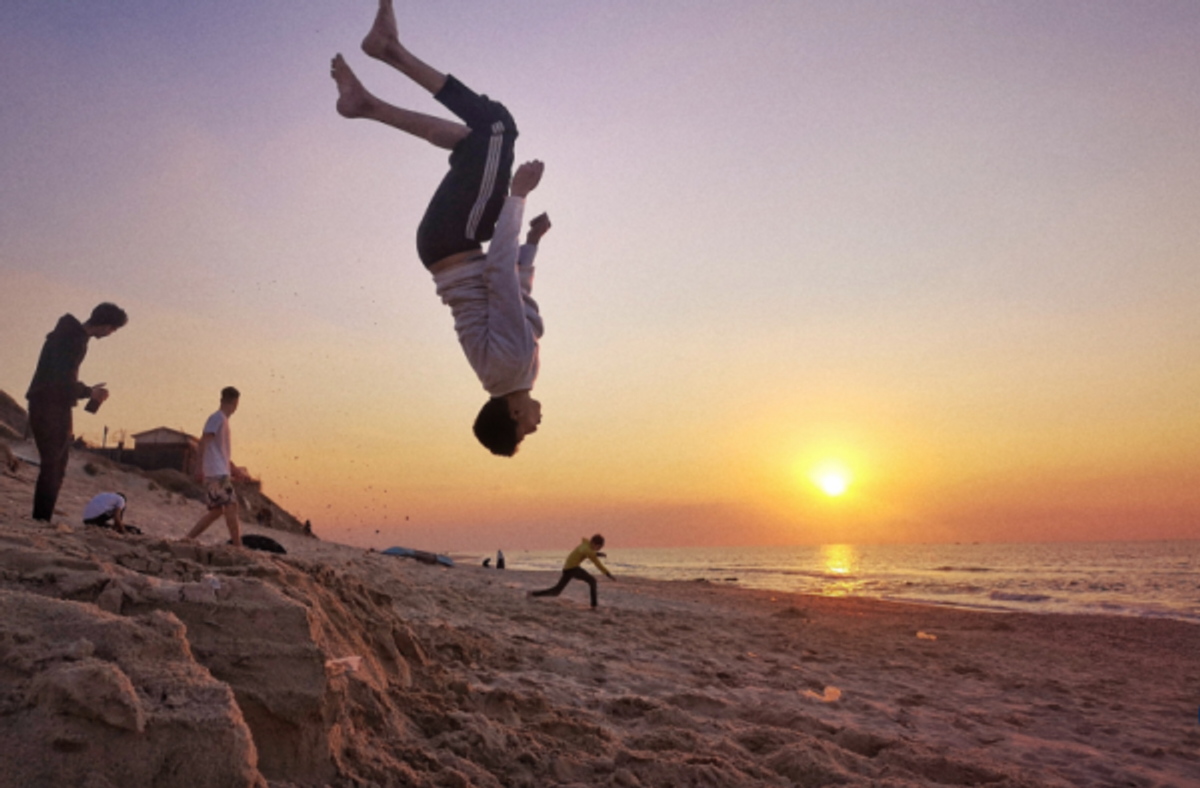 男孩们在海滩上跳跃，这是摄影师 Majd Arandas 展示“加沙的欢乐和美丽”使命的一部分。