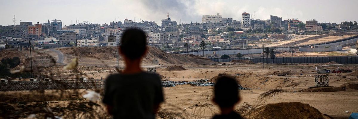 Boys watch over smoke billowing in Gaza