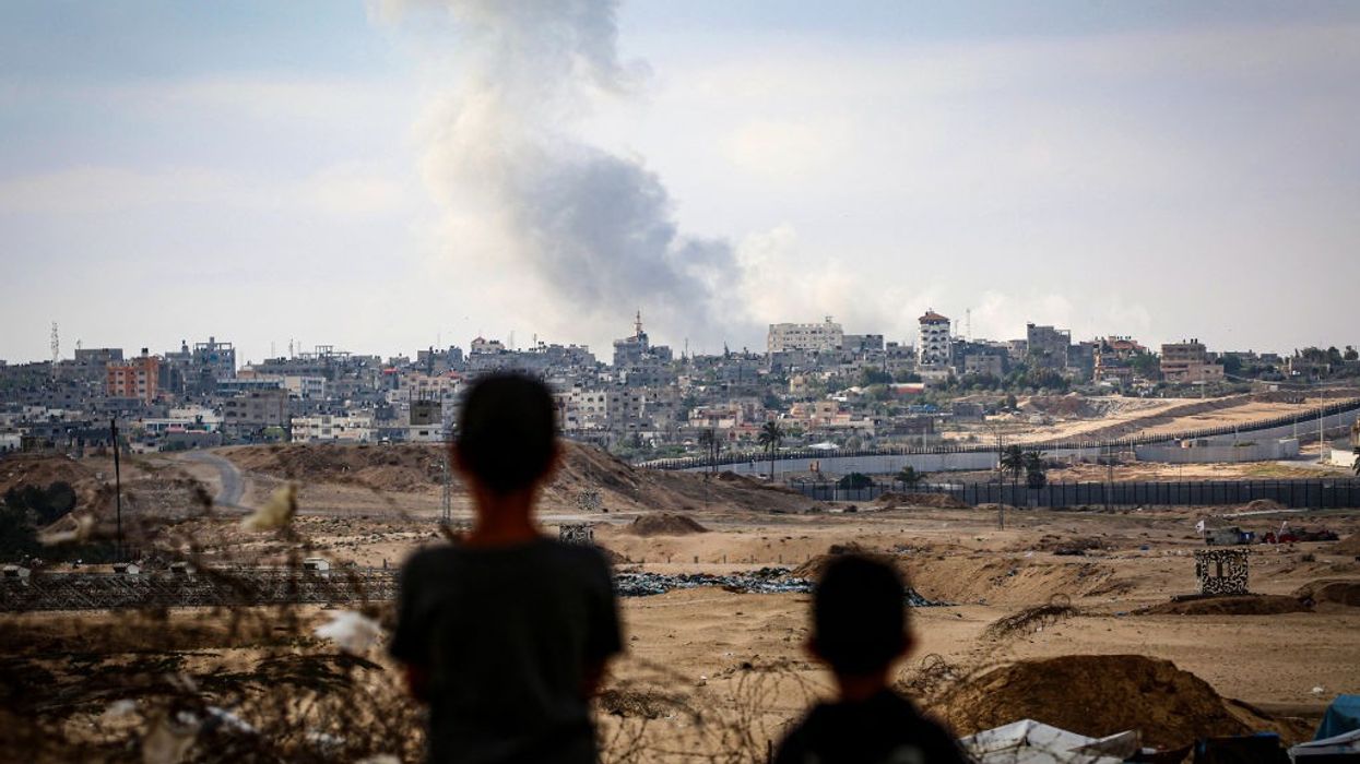 Boys watch over smoke billowing in Gaza