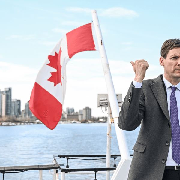 British Columbia Premier David Evy gestures toward a Canadian flag