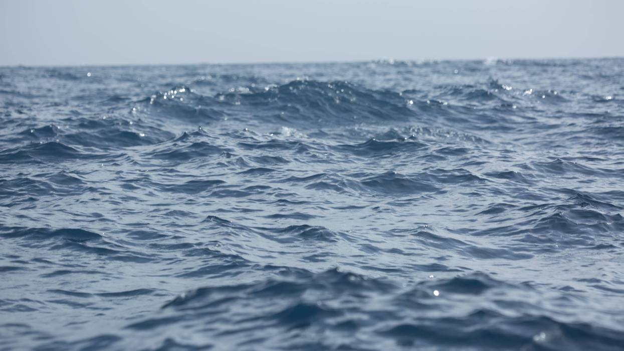 Calm Blue Ocean Water with Sparkling Sunlight Reflections and Hazy Horizon