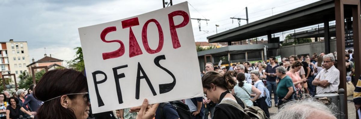 campaigner with "stop pfas" sign