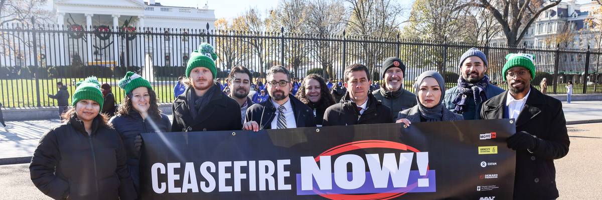 campaigners hold up cease-fire now banner at white house
