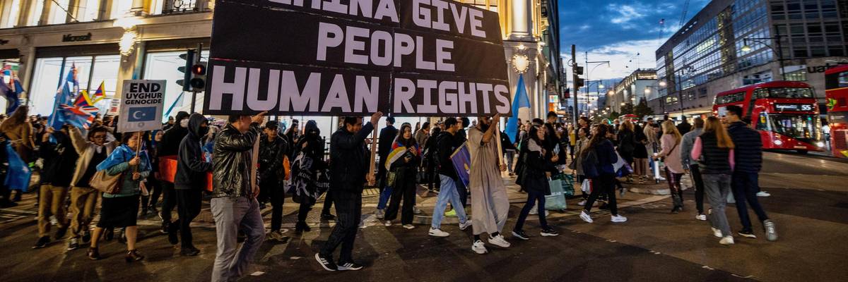Campaigners march under banner that reads"China Give People Human Rights" in London