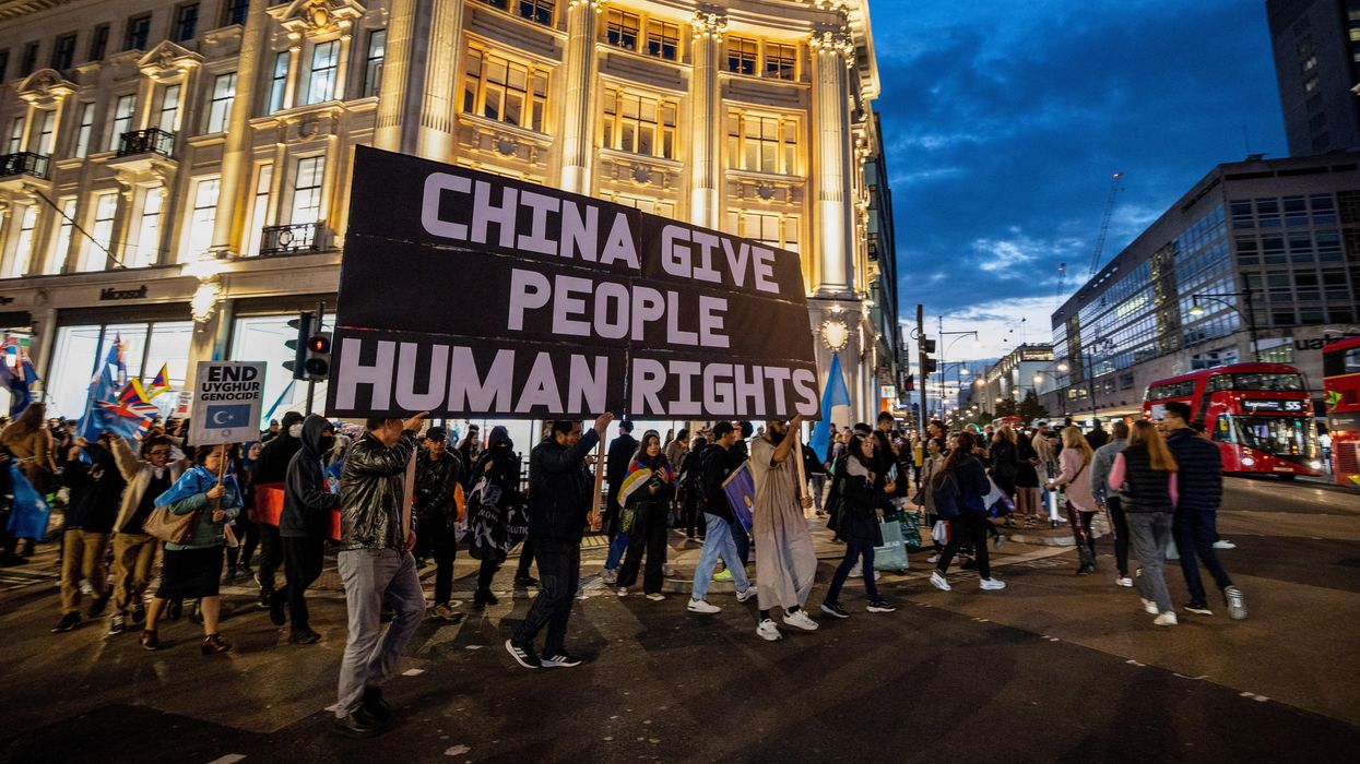 Campaigners march under banner that reads"China Give People Human Rights" in London