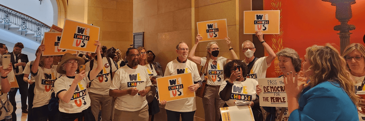 Campaigners with We Choose Us celebrate the passage of the Democracy for the People Act