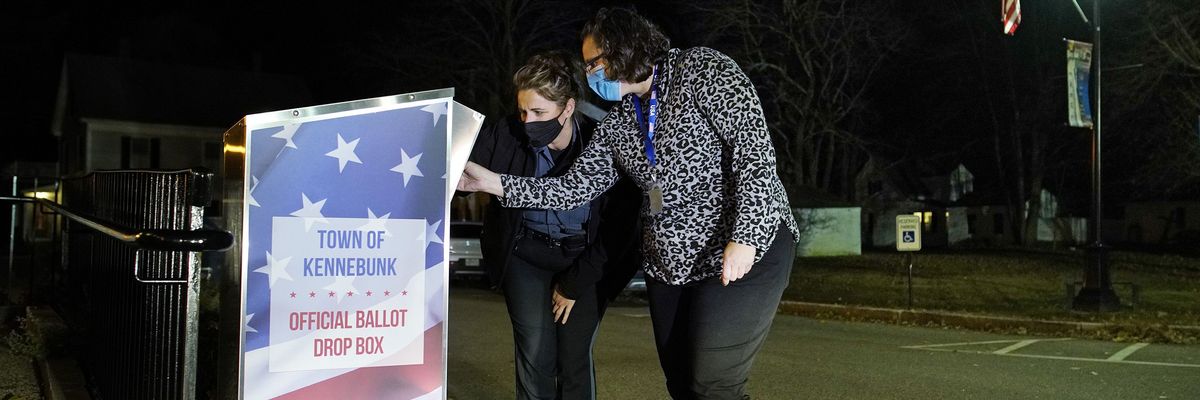 Carrie Weeman, the deputy clerk of Kennebunk, Maine, and police officer Candice Simeoni open an absentee ballot kiosk outside of town hall