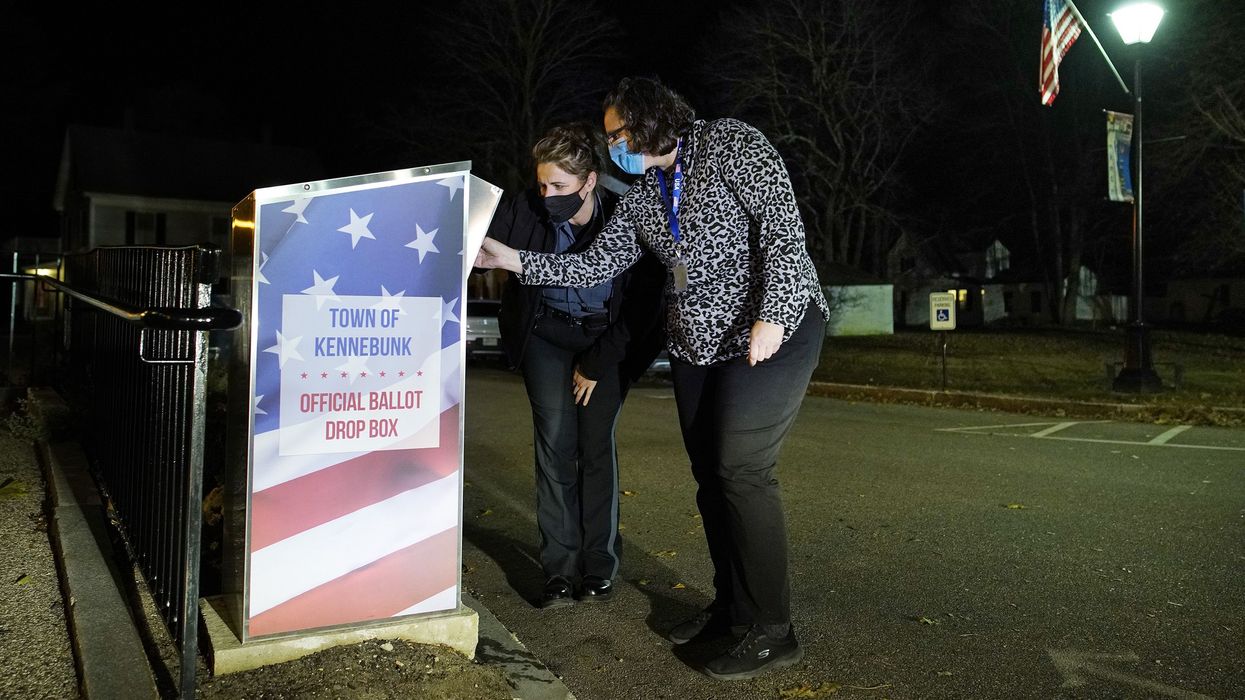 Carrie Weeman, the deputy clerk of Kennebunk, Maine, and police officer Candice Simeoni open an absentee ballot kiosk outside of town hall