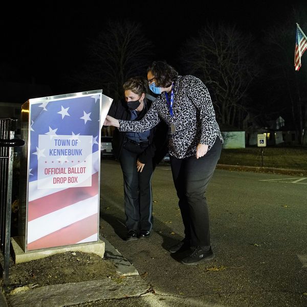 Carrie Weeman, the deputy clerk of Kennebunk, Maine, and police officer Candice Simeoni open an absentee ballot kiosk outside of town hall