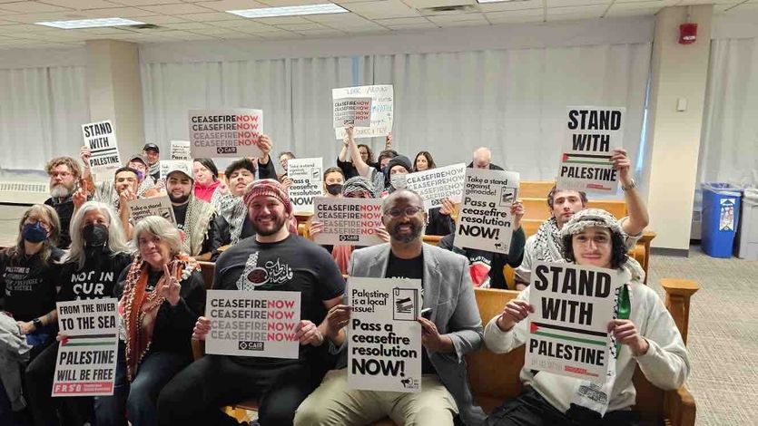 Cease-fire supporters hold signs.