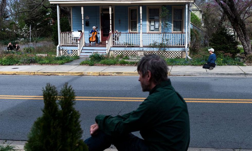 Cellist Jodi Beder performs a daily concert on her front porch in Mount Rainier, Maryland, near Washington, D.C., on March 30, 2020. Beder started the performances to help her neighbors, and passersby, cope with the coronavirus pandemic. Andrew Caballero-Reynolds/AFP/Getty Images)