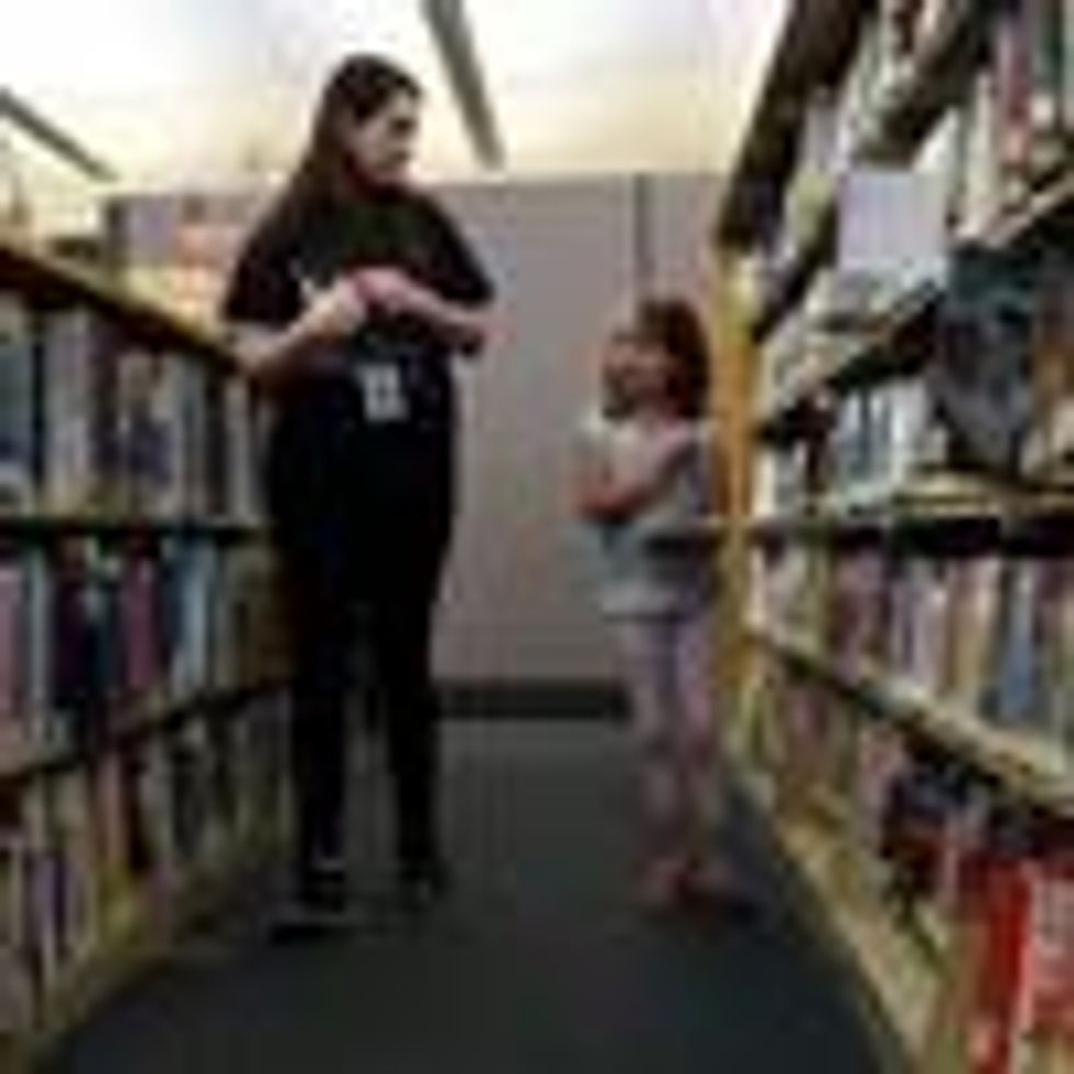 Child and librarian looking for books