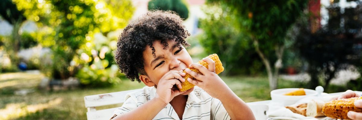 child eating corn