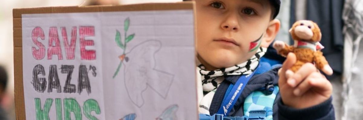 child holds placard for Gaza