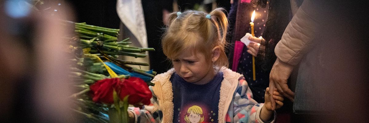 Child mourns at funeral during Ukraine war