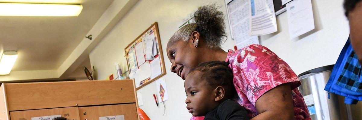 Childcare worker sits with children