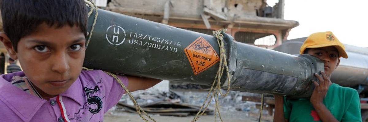 Children carry an empty US ammunition container in Gaza