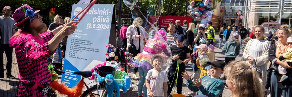 Children enjoy a soap bubble performance at Malmi Suburb during Helsinki Day