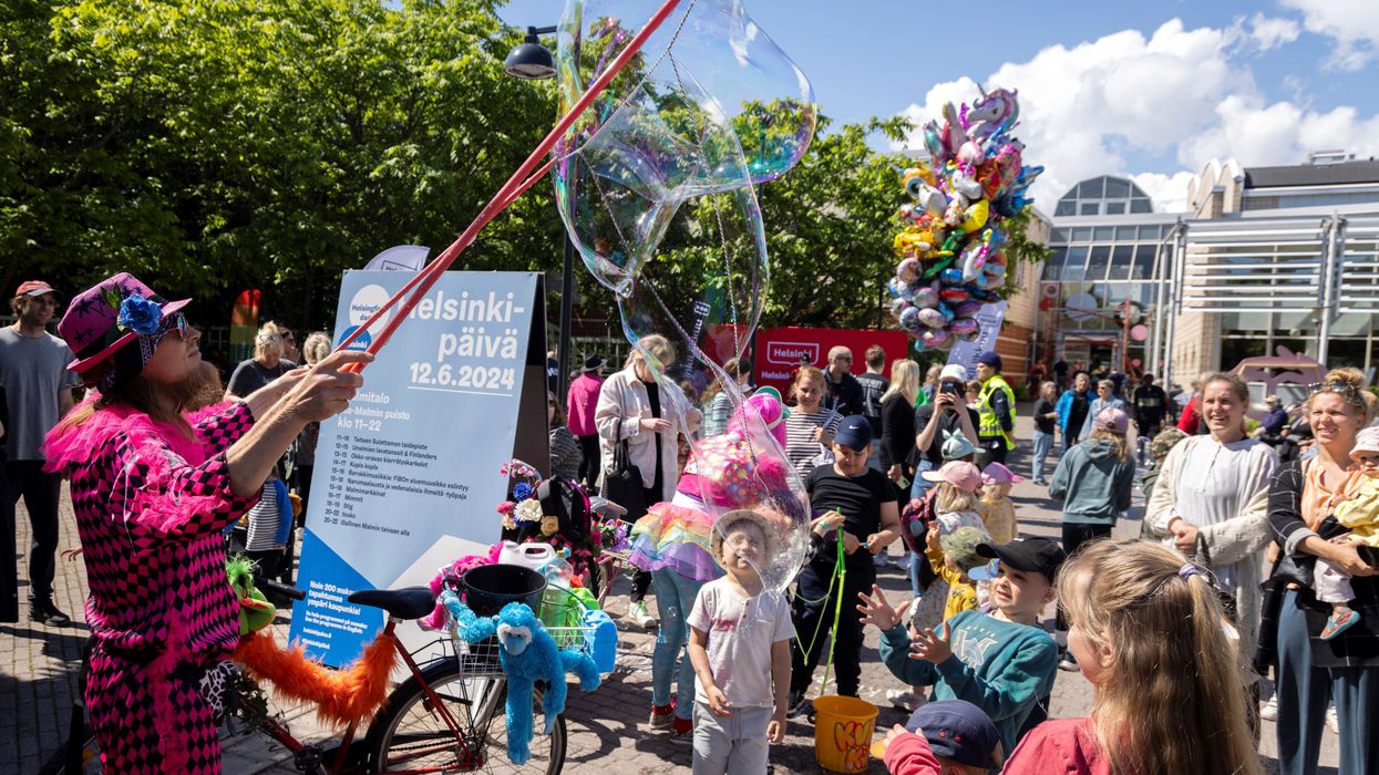 Children enjoy a soap bubble performance at Malmi Suburb during Helsinki Day