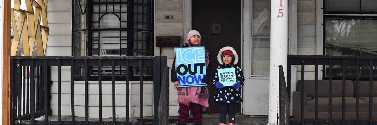 Children held signs as protesters marched in Minneapolis against Immigration and Customs Enforcement