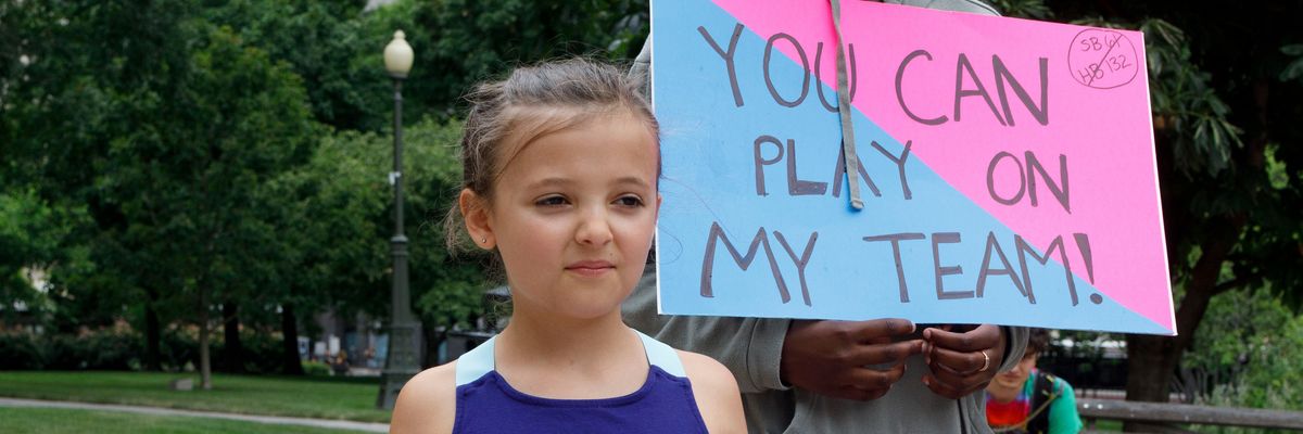 Children hold placards supporting transgender children