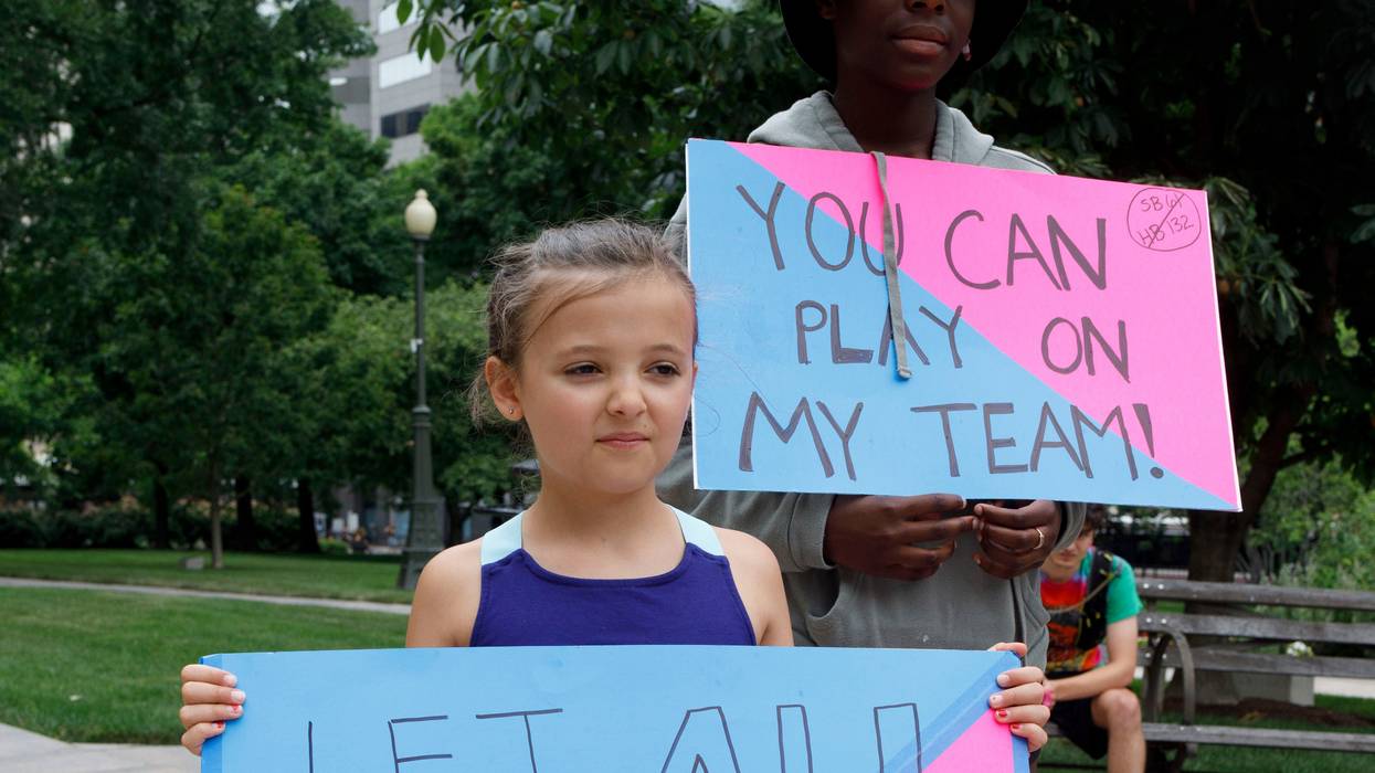 Children hold placards supporting transgender children