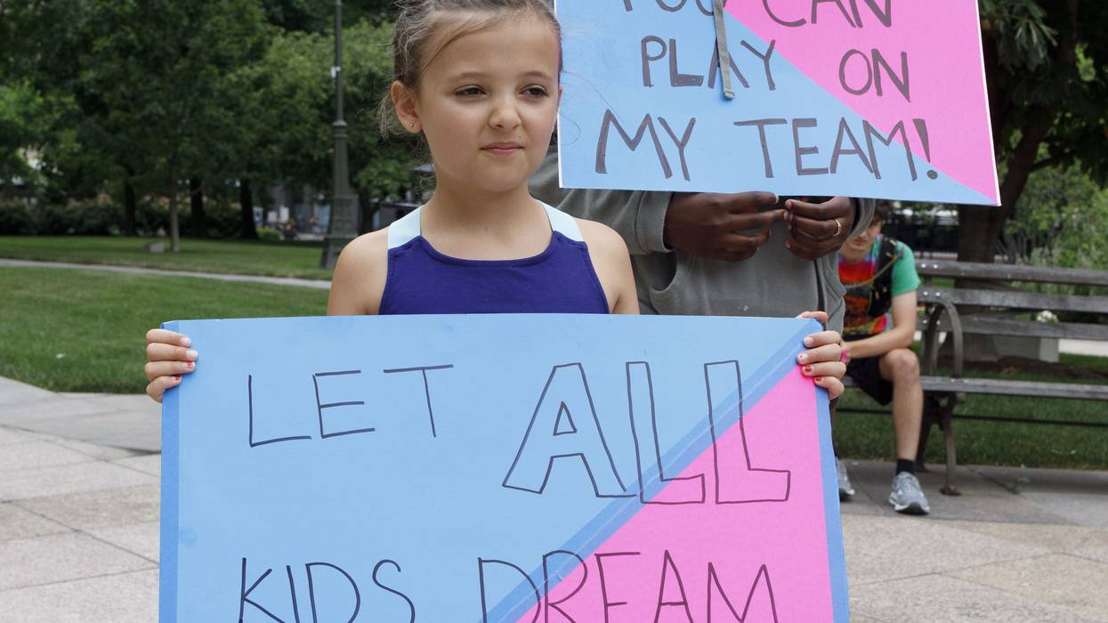 Children holding placards supporting trans children, during