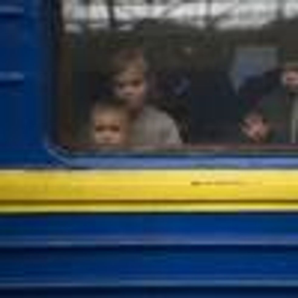 Children look out from a carriage window as a train prepares to depart from a station in Lviv, western Ukraine, en route to the town of Uzhhorod near the border with Slovakia, on March 3, 2022. (Photo: Daniel Leal/AFP via Getty Images)