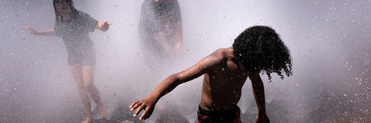 Children play in the Salmon Springs Fountain during the Northwest Heatwave