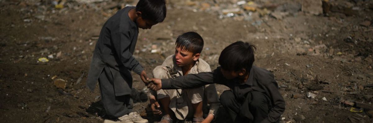 Children scavenge scrap metals in Kabul on July 26, 2022.