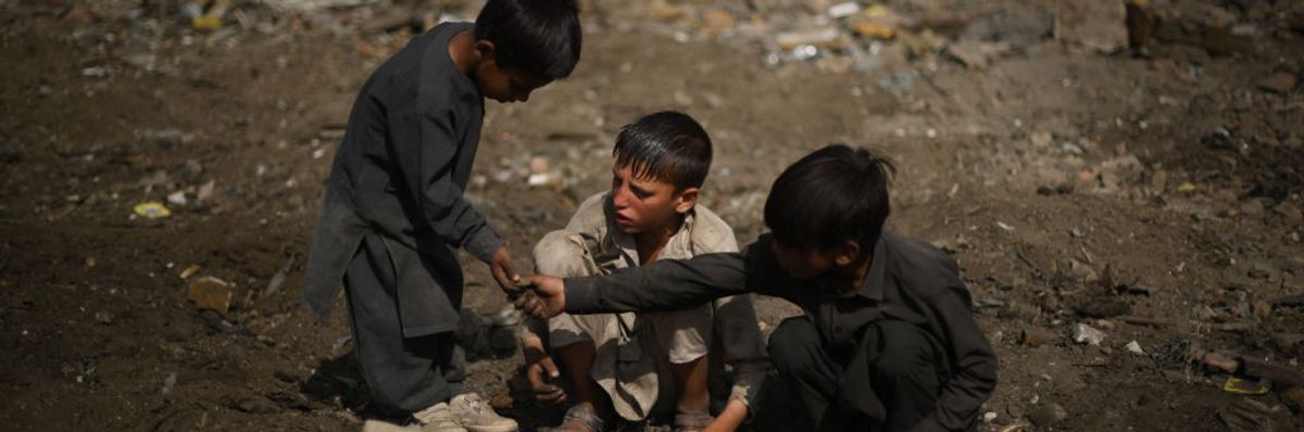 Children scavenge scrap metals in Kabul on July 26, 2022. 