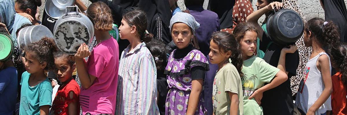Children wait in a food line in Gaza