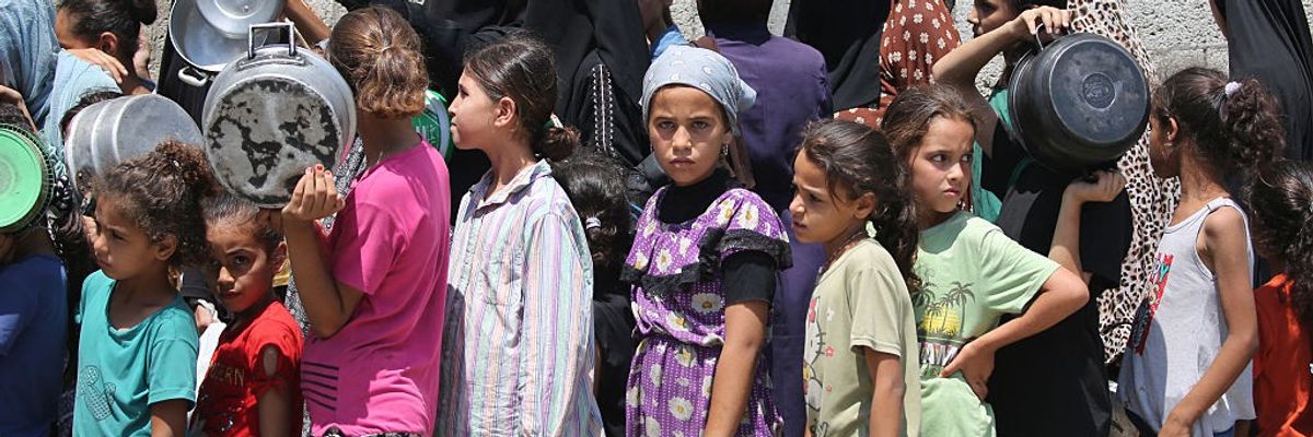 Children wait in a food line in Gaza