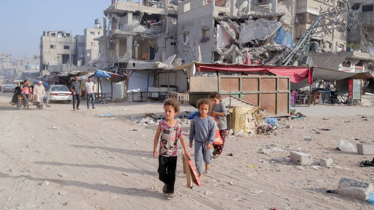 Children walk amongst the rubble