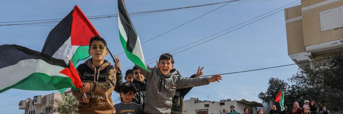 Children wave Palestinian flags.