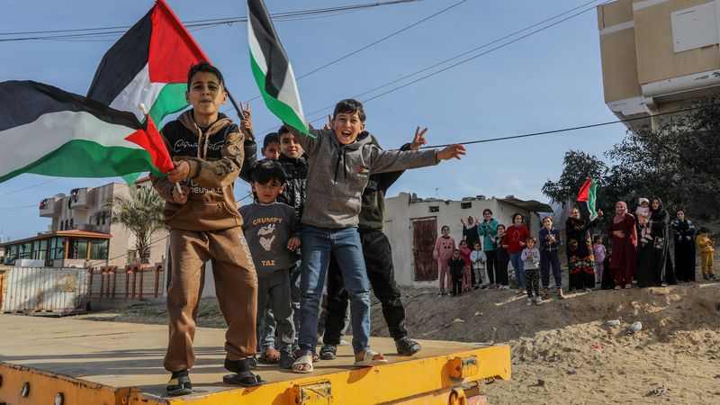 Children wave Palestinian flags.