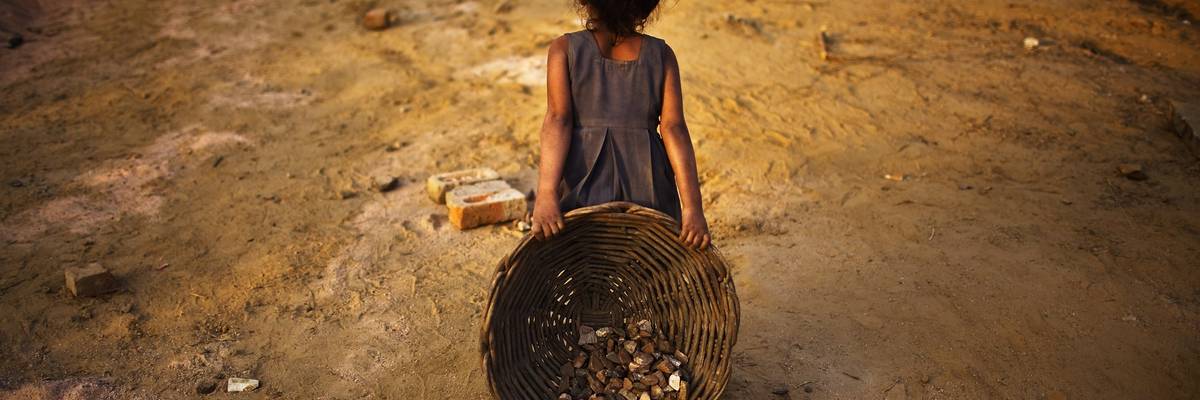 Children work alongside their parents at a construction site in front of the Jawaharlal Nehru Stadium in New Delhi, India on January 30, 2010.